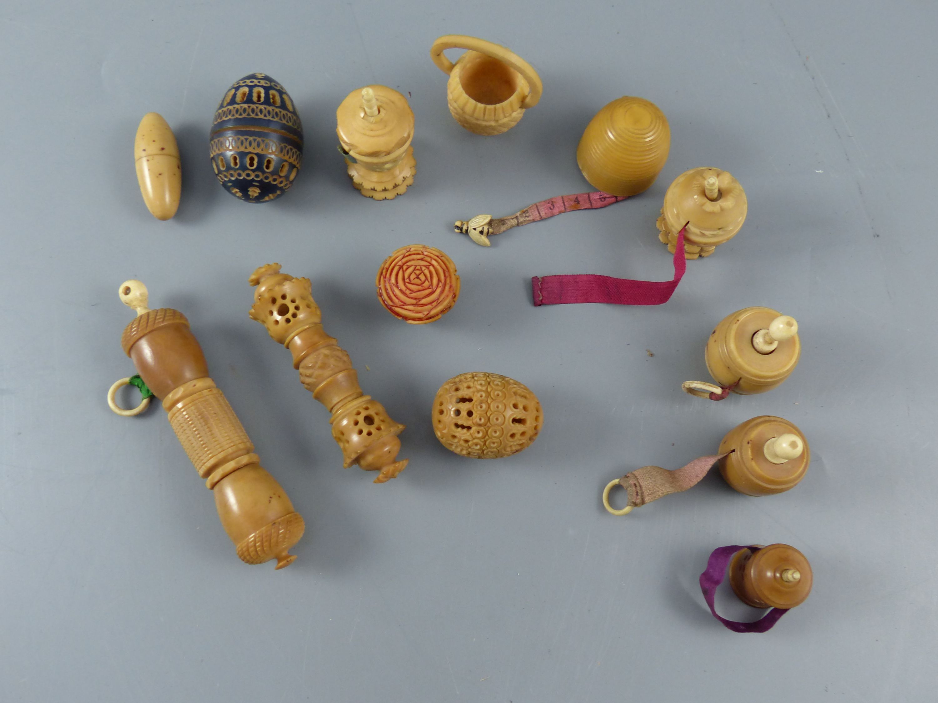 A collection of assorted 19th century carved and turned coquilla nut sewing accessories